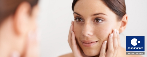 Image of a woman touching her face and seeming happy about how wonderful her skin feels.