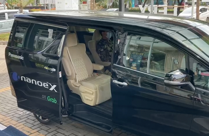Un cliente está sentado en un coche de la colaboración de Grab y nanoe™ X.