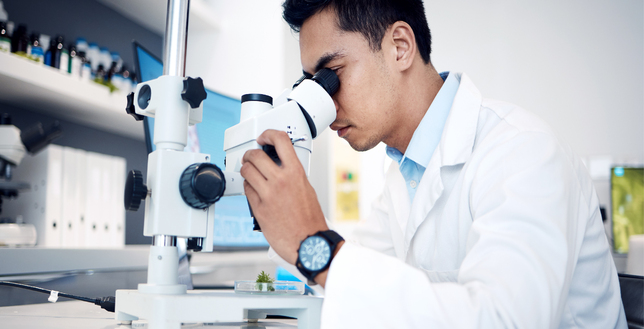 Scientist in a lab using a microscope