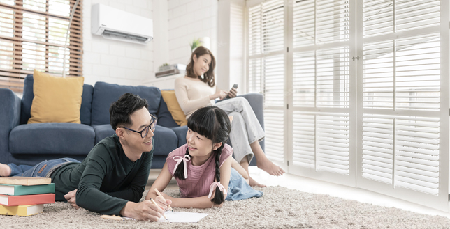 Family of three in living room featuring Panasonic air conditioner