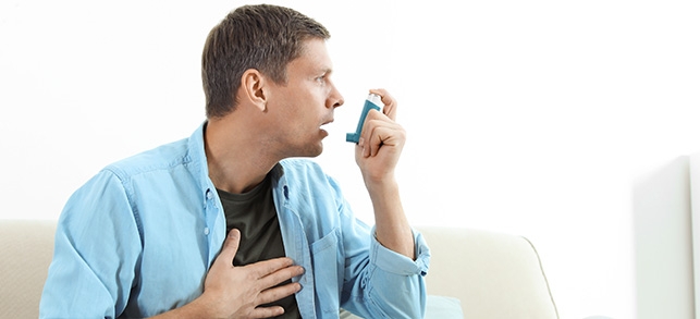 A man using an asthma inhaler