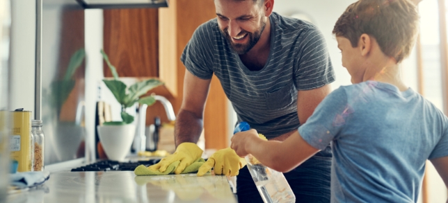 A photo of a father and son cleaning a kitchen