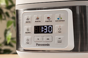 Primer plano de la pantalla digital de la olla arrocera blanca SR-DA152WXE que muestra un temporizador de cuenta regresiva.