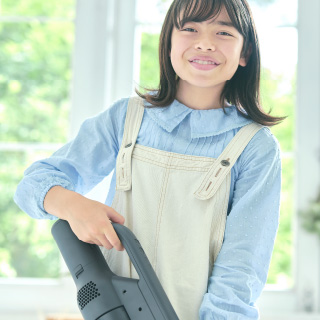 طفل يحمل مكنسة كهربائية