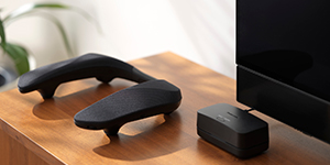 Close-up of a neck speaker and its charging case on a wooden surface.