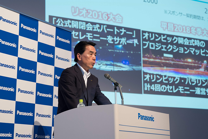 Photo : Directeur général Masahiro Ido sur le podium, expliquant la vision et les initiatives de l'entreprise.