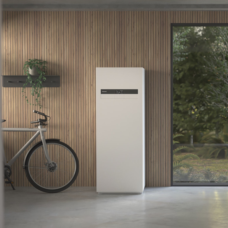 A white rectangular boiler is placed against the wall. To the left, a bicycle leans against the wall. 