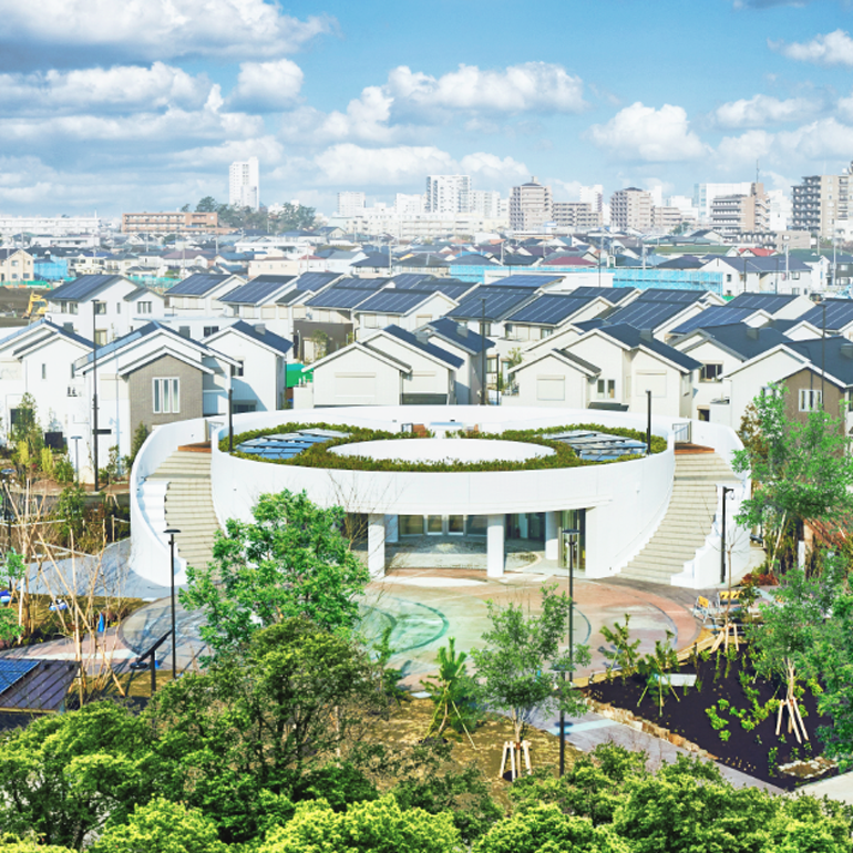 Aerial view of an urban area with buildings, roads, and greenery.