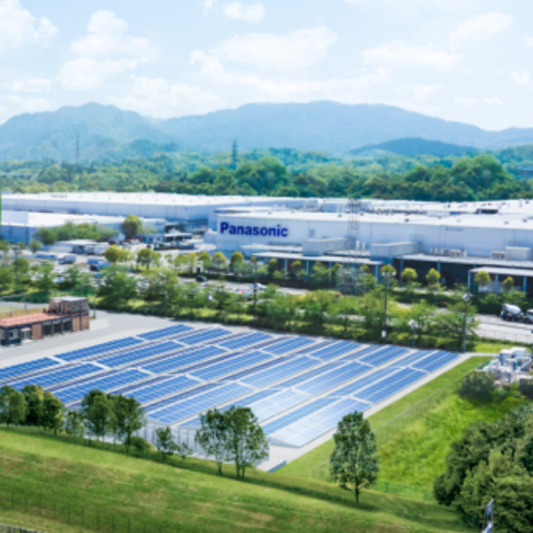 Aerial view of a large building complex surrounded by trees and vegetation.