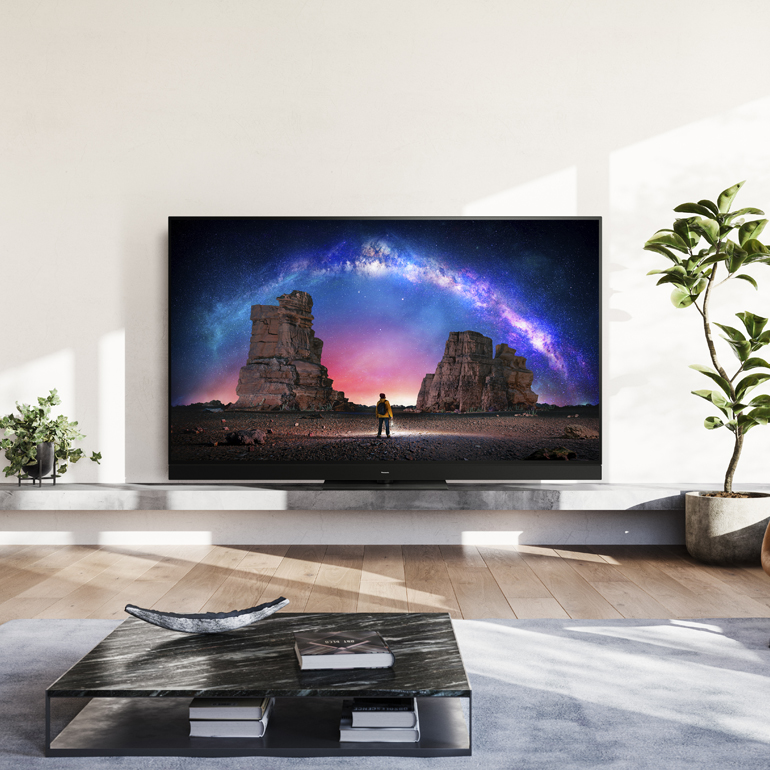 living room with a large flat-screen TV displaying a starry night sky and mountains