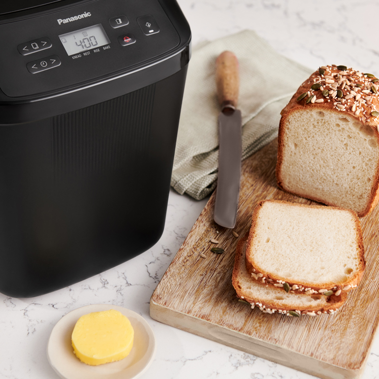 Liten brödmaskin bredvid bröd med texten Liten brödmaskin. Mycket smak. Minskar matsvinn.