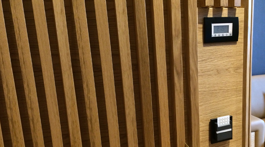 An image of a wooden wall with a card holder and a light switch