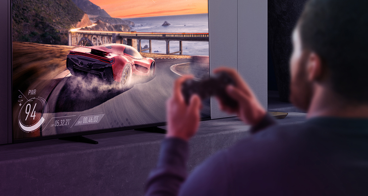 A man plays a video game with a car race on a Panasonic television