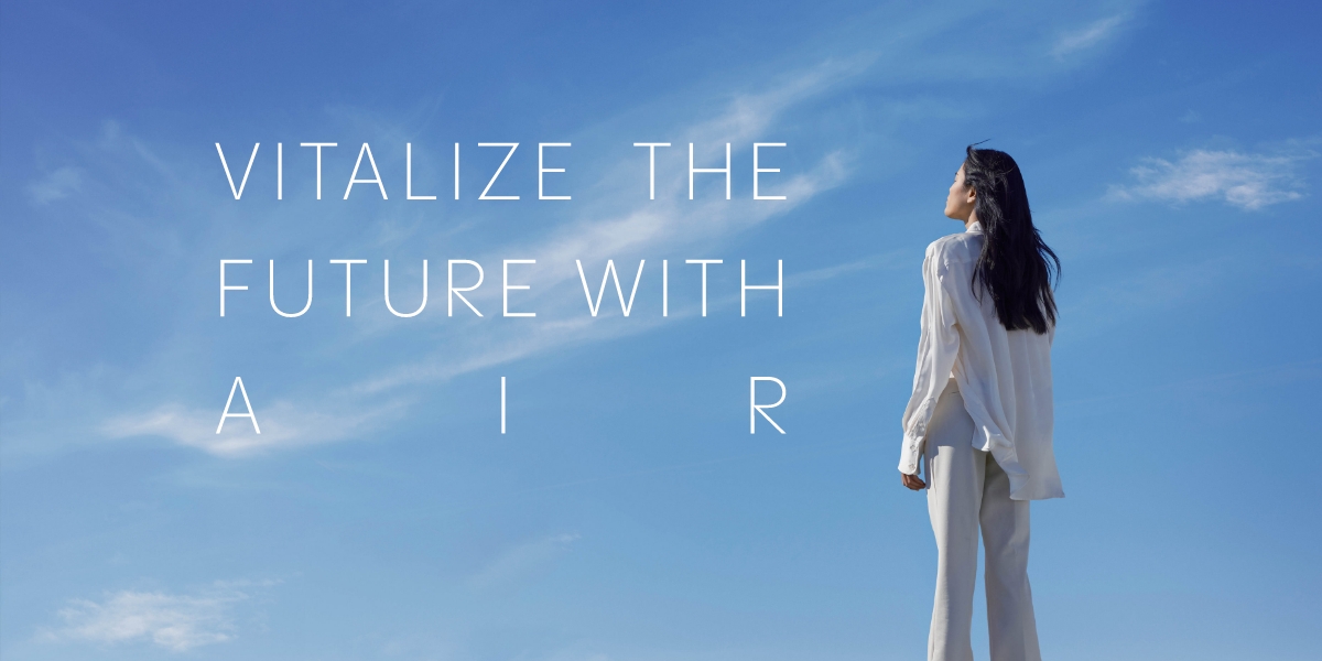 An image of a woman looking up the blue sky while being feeling the breeze of the wind.