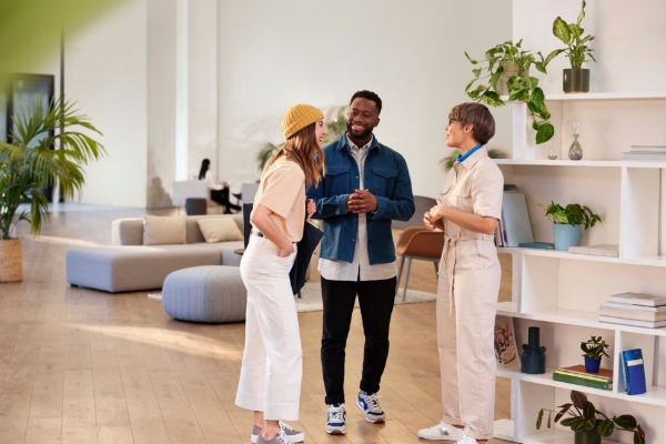 An image of a man and two women talking together at the office.