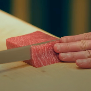 Close-up of meat being thinly sliced