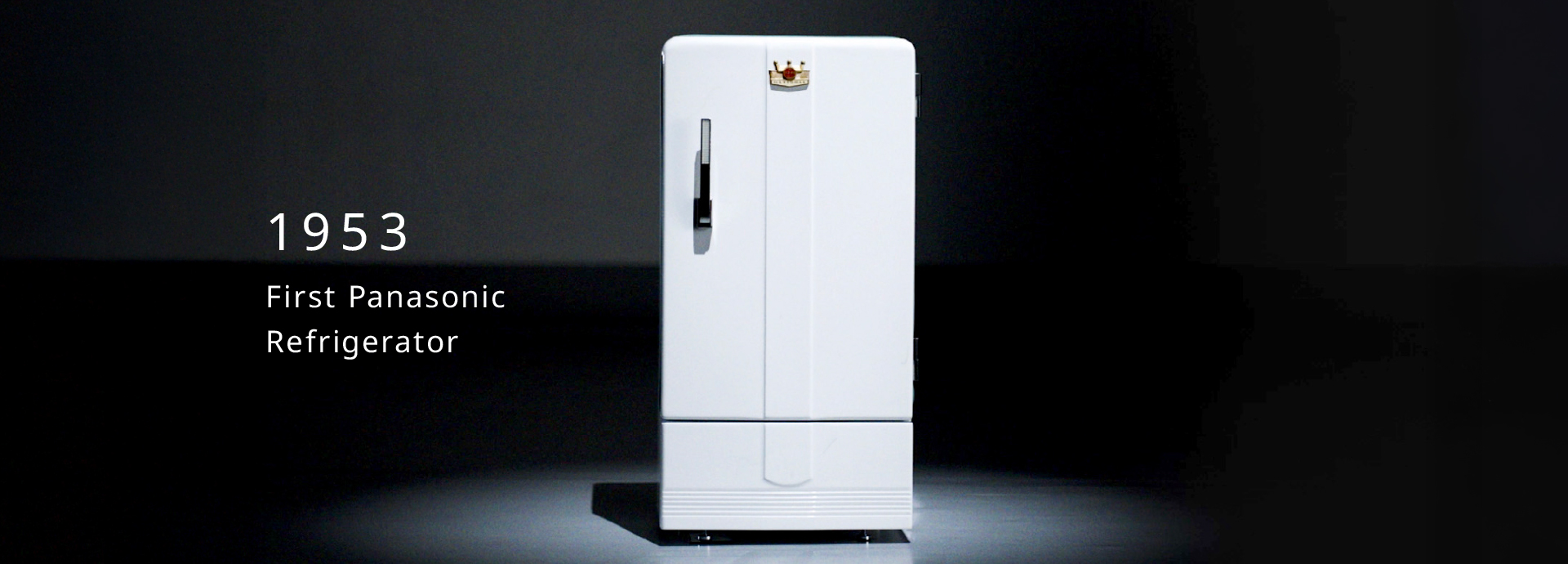 1953’s First Panasonic Refrigerator in a spotlight against a dark background.