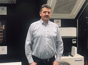 An image of a boss standing in front of air conditioners