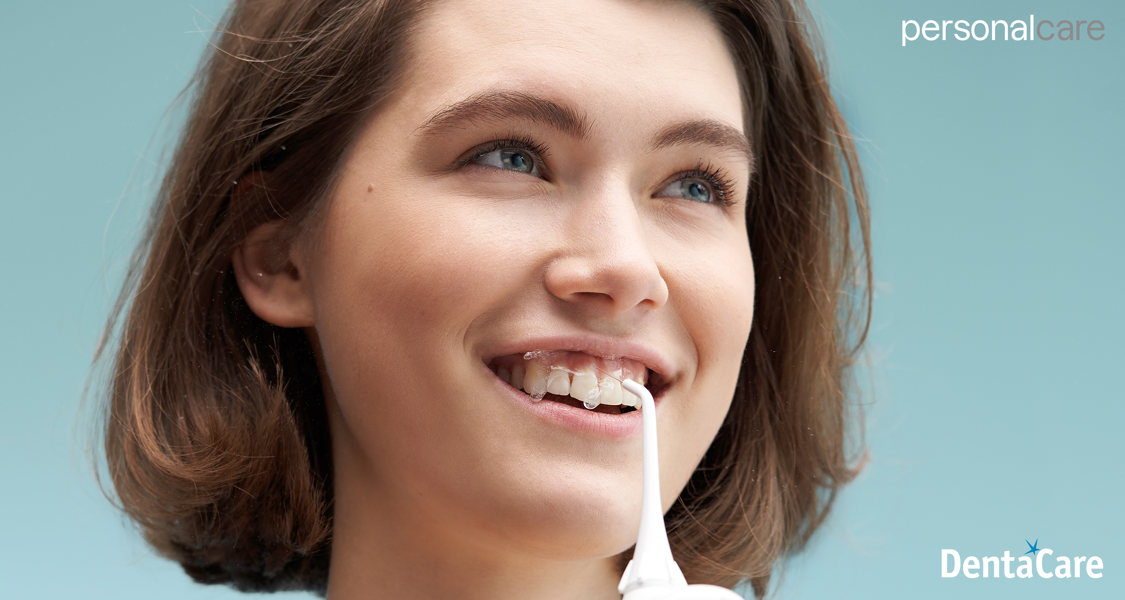 Młoda szczęśliwa kobieta ze zdrowymi zębami korzysta z irygatora Panasonic EW1311 do jamy ustnej