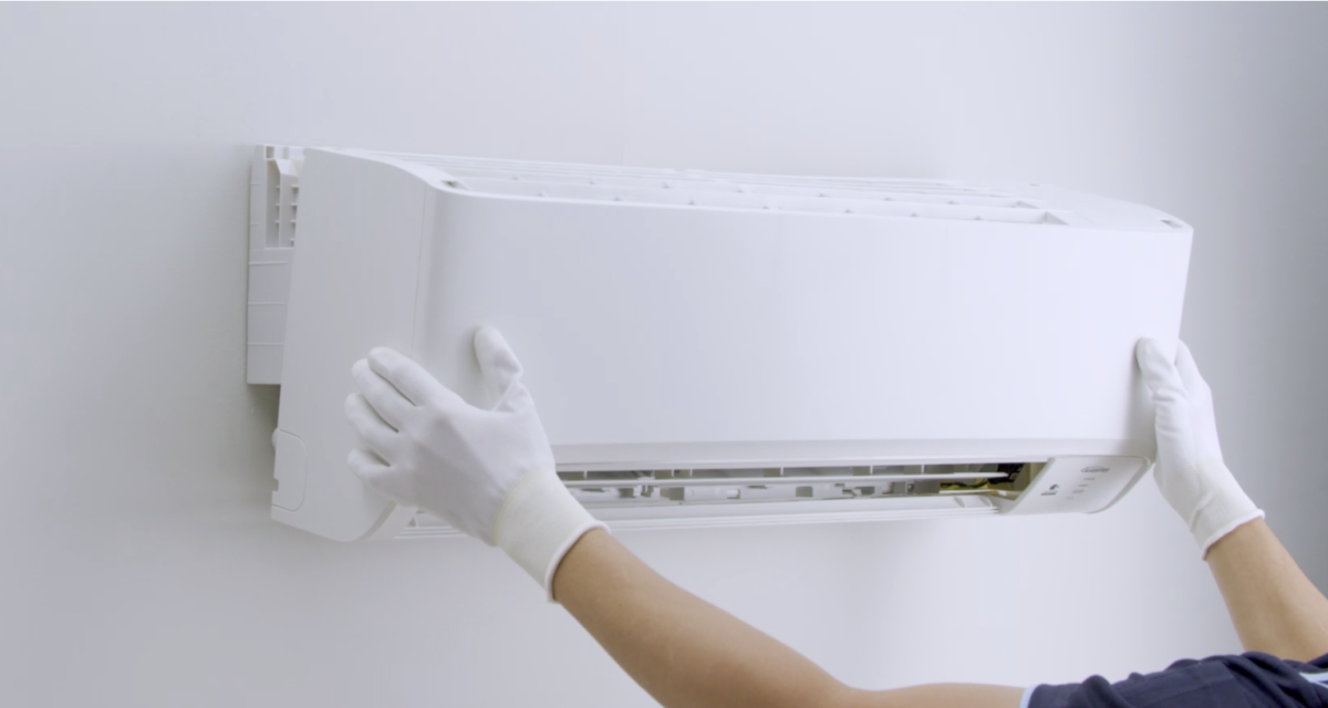Serviceman installing the aircond onto the wall
