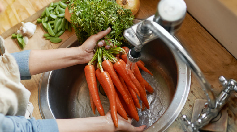 An image of vegetables being washed with water
