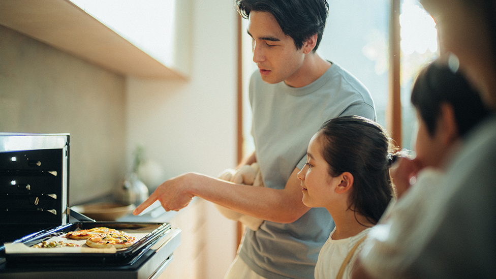 Image of father and daughter cooking together using a microwave oven.
