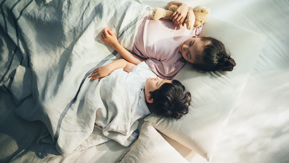 Image of children sleeping comfortably in clean sheets