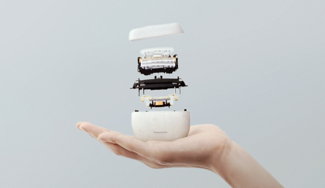 Exploded view image of a compact, white LAMDASH Palm In shaver, resting in the palm of a hand.