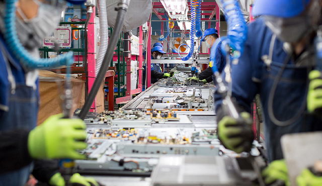 Photo of workers on a line dismantling end-of-life TVs in the Panasonic Eco Technology Centre.