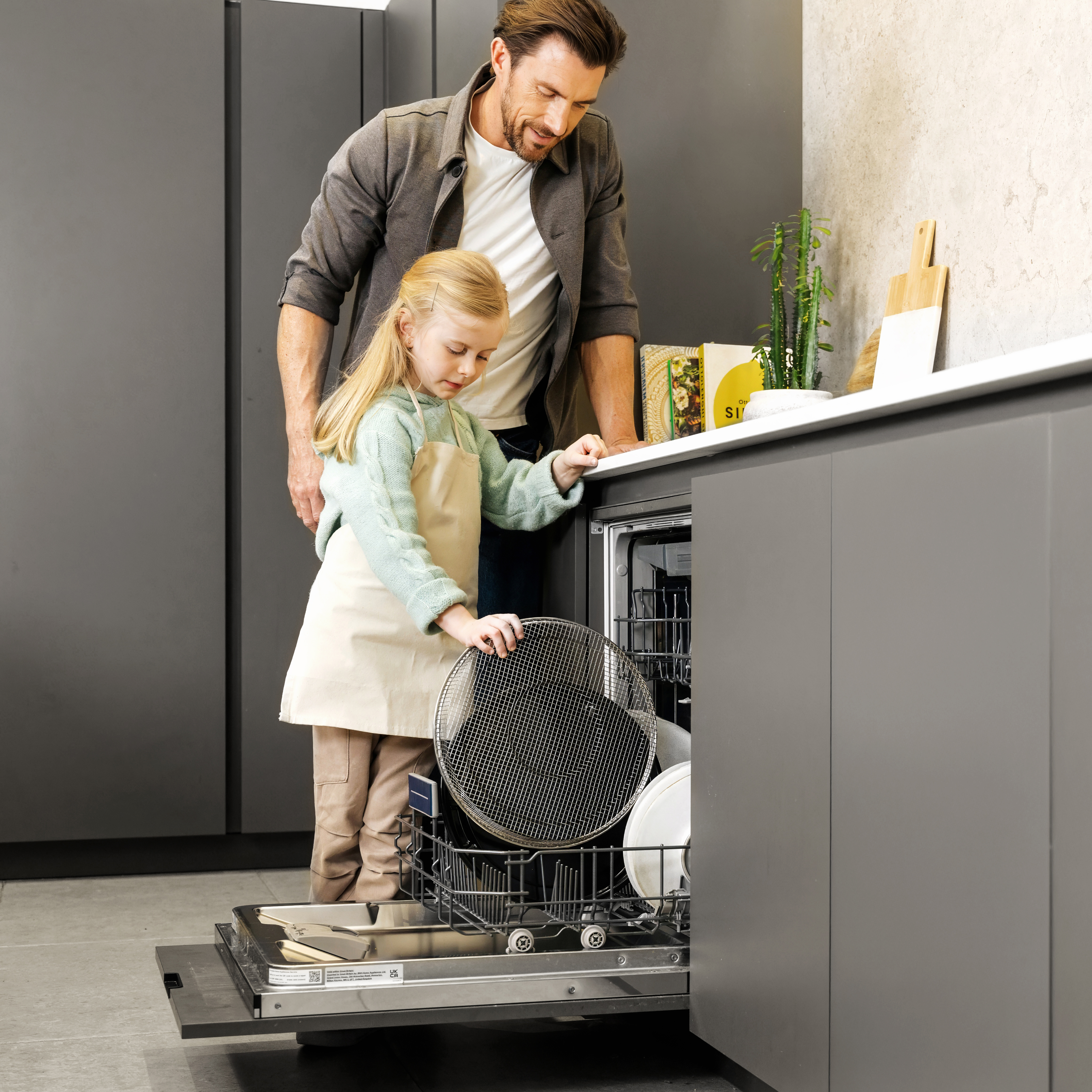 Far og datter lægger airfryerkurven i opvaskemaskinen