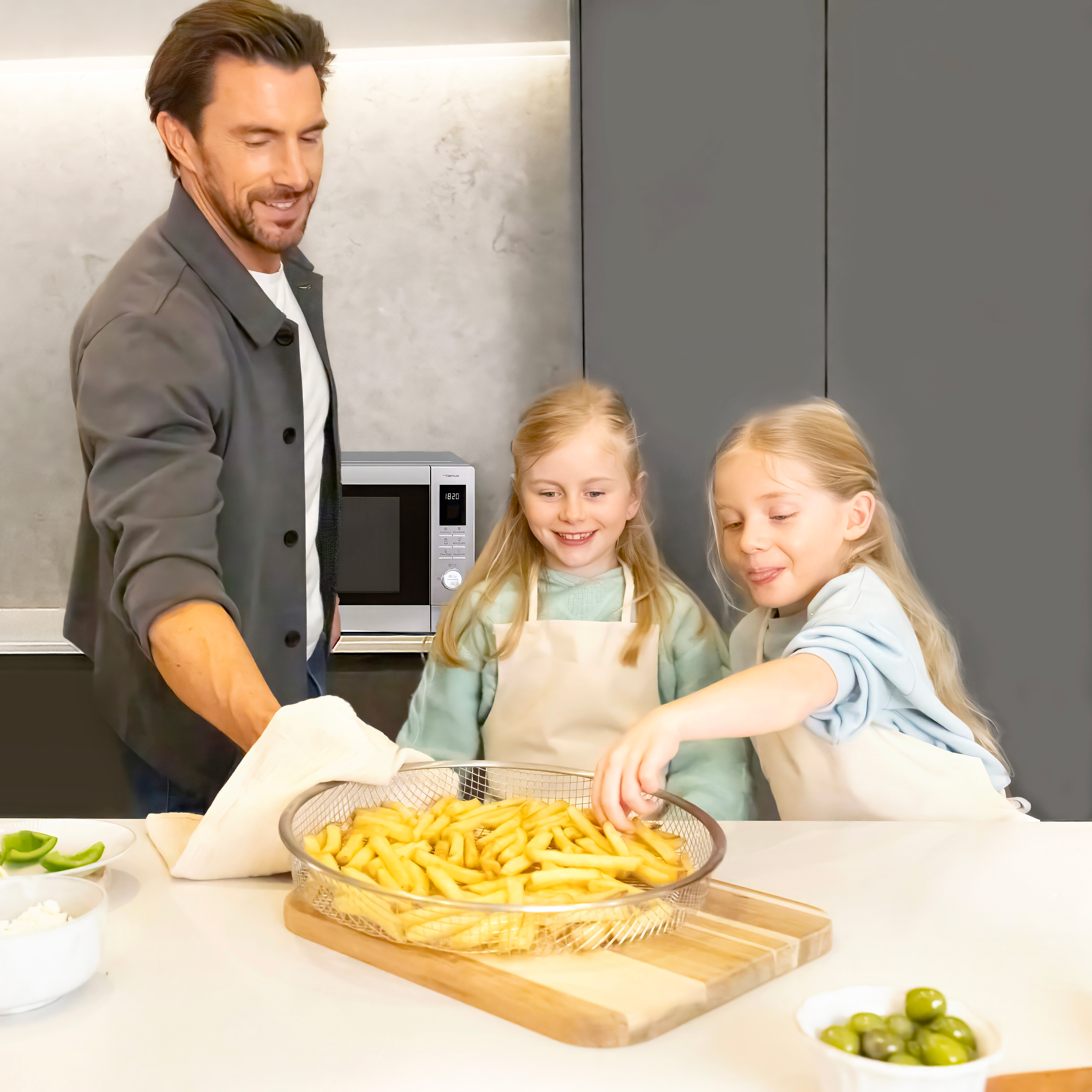 Far og døtre med frisklavede pommes frites og airfryerkurven