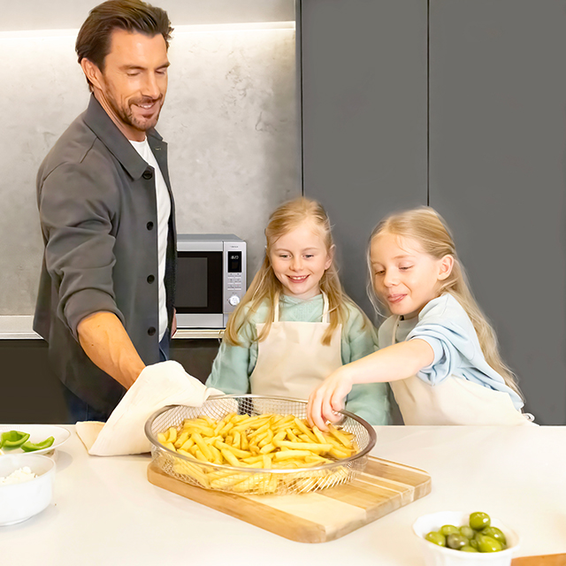 Far og døtre med frisklavede pommes frites og airfryerkurven