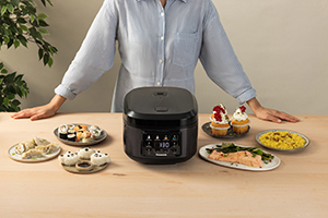 Person in the background with a table full of various steamed rice dishes in the foreground.