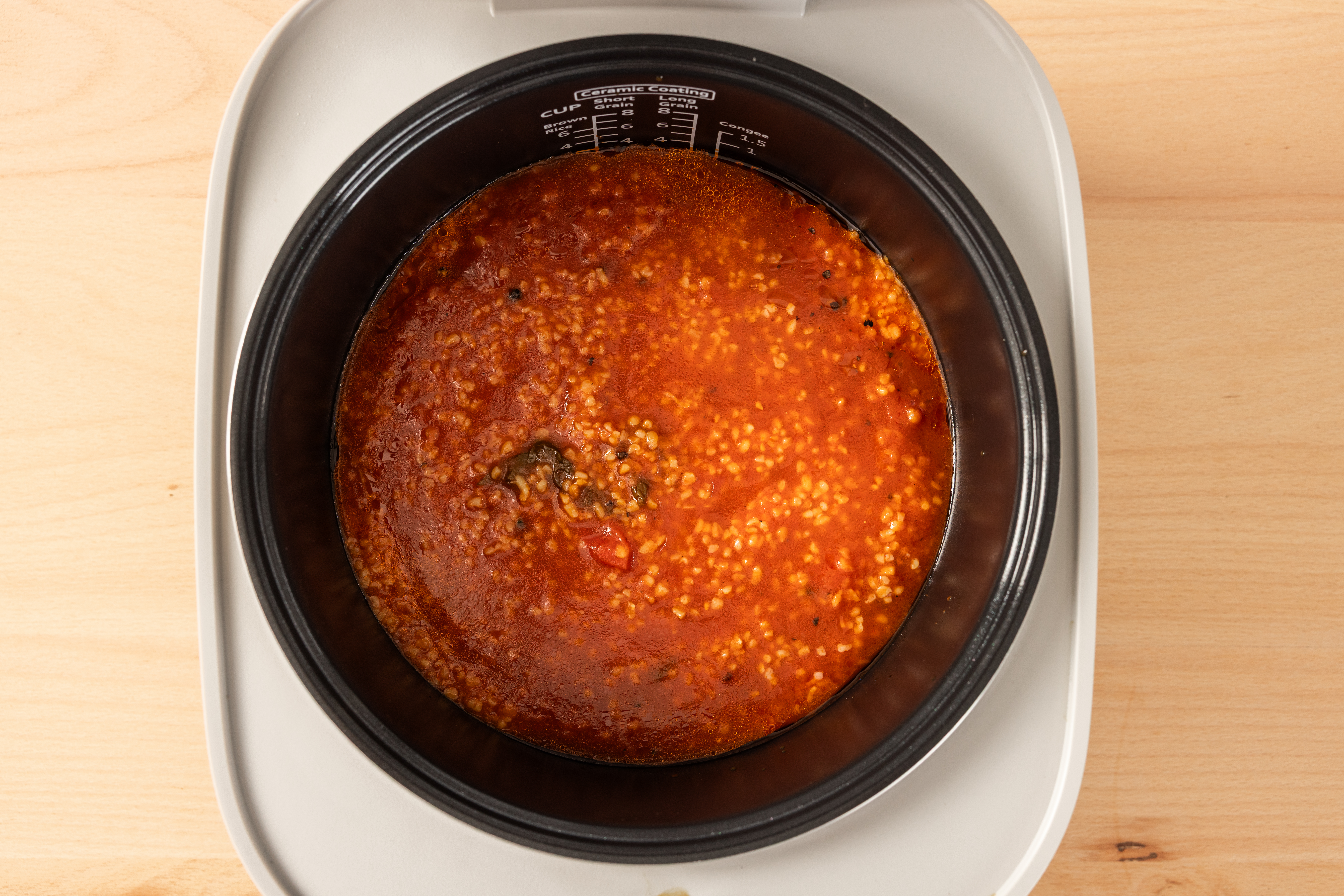 Top view of the SR-DA152WXE Rice Cooker in White filled with tomato, basil, and lemon bulgur soup.