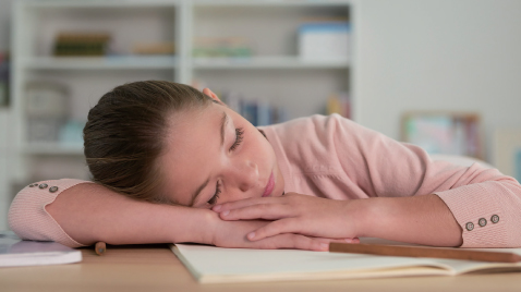 A girl fall asleep while studying