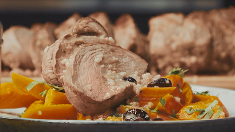 Roast lamb stuffed with lemon-couscous on glazed carrots