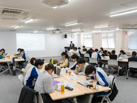 Photo of MIRAI Scholarship recipients interacting with Panasonic engineers, highlighting efforts to foster learning and career inspiration through cross-generational exchange.