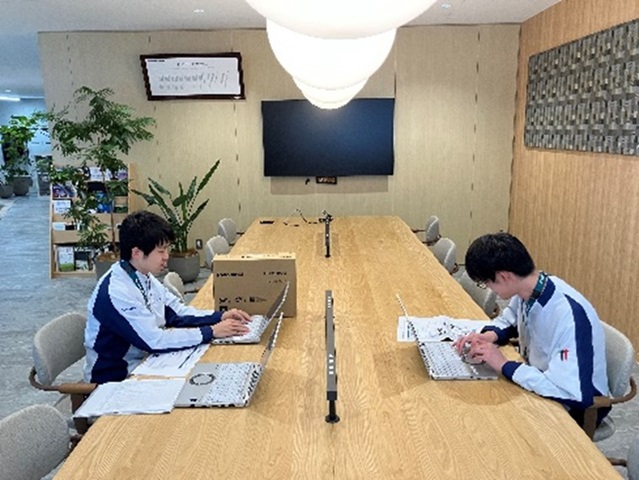 Photo of Office Concierge members setting up laptops for new employees, showcasing Panasonic’s inclusive workplace initiatives that expand opportunities for employees with disabilities.