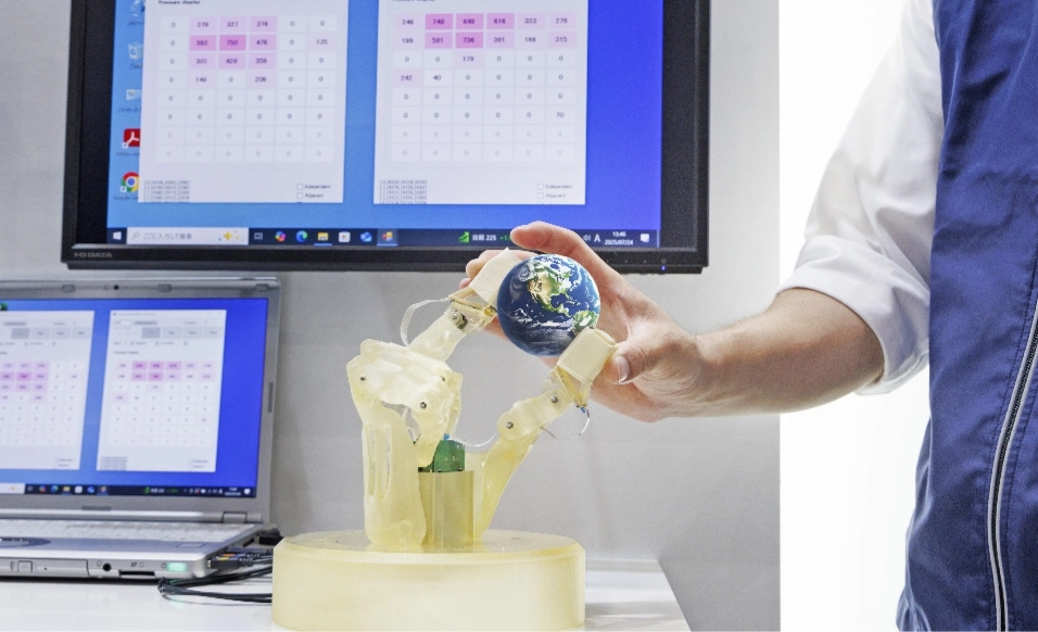 指先に感圧センシングデバイスが付いたロボットハンドのデモ。ボールに触れた部分の圧力が画面に投影される