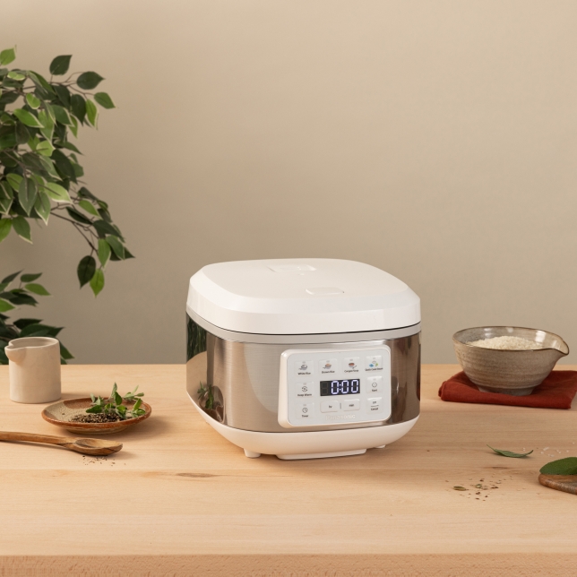 Front view of the SR-DA152WXE Rice Cooker in White surrounded by spices and kitchen utensils.