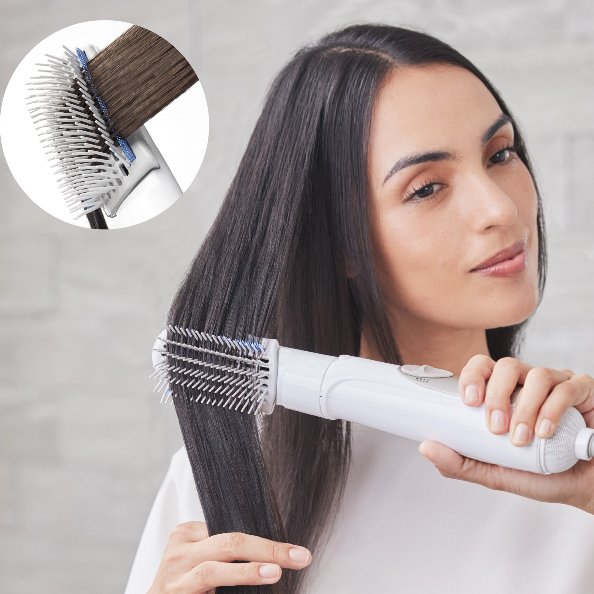 A woman with long, smooth dark hair using Panasonic hair styler with blow brush.