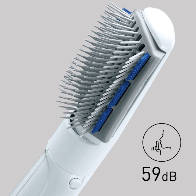 A woman blow-drying her hair with a hair styler. An icon and text '59 dB' indicate a quiet operation, with a finger raised over lips for silence.