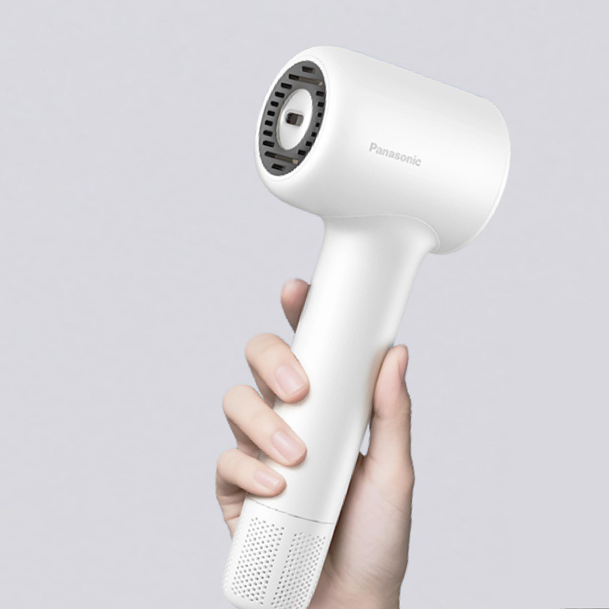 A hand effortlessly holding the compact, Panasonic hair dryer, emphasizing the product's lightweight design and ease of handling.