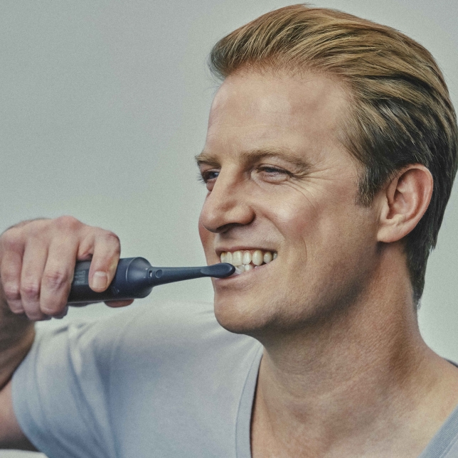 Close up of male using Multishape with toothbrush attachment