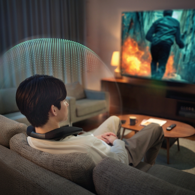 Person relaxing at home wearing SC-GNW30, enjoying surround sound without disturbing others.